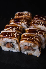 Sushi rolls on a black background, Japanese cuisine