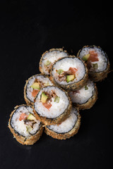 Sushi rolls on a black background, Japanese cuisine