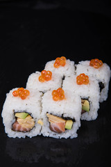 Sushi rolls on a black background, Japanese cuisine