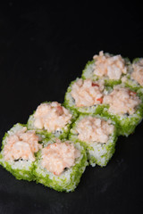 Sushi rolls on a black background, Japanese cuisine