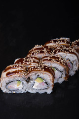 Sushi rolls on a black background, Japanese cuisine