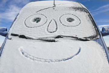Snow-covered car with smiley