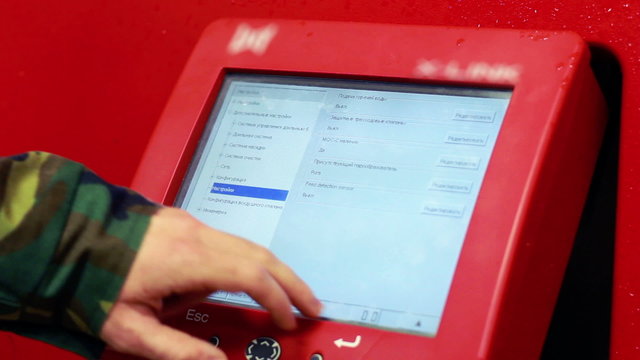 Men operating on LCD display of computerized milking machine