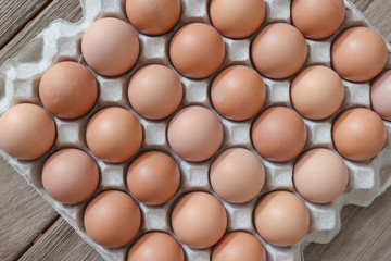 Eggs in paper tray on wood background