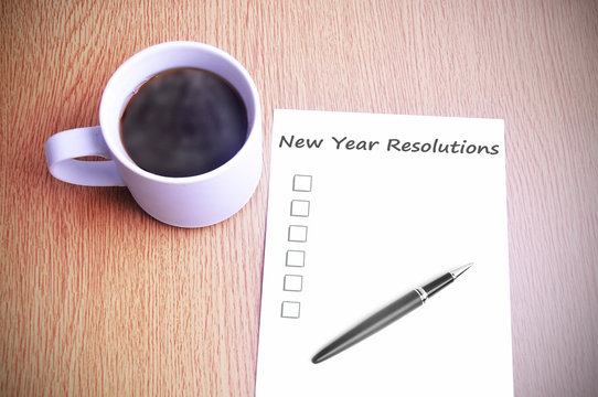 Coffee on the table with note writing new year resolutions