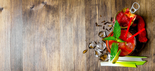 Making a cocktail with vodka, tomato paste and other ingredients on wooden background . Free space...