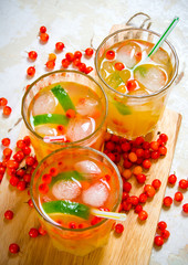 Three cocktails from sea-buckthorn berries , ice and lime on the old table .