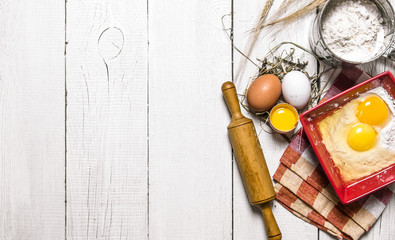 Baking background. Ingredients for the dough - Egg, flour and a rolling pin.
