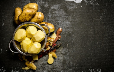 The concept of wet peeled potatoes on a stone background . Free space for text.