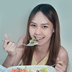 Close-up Of Beautiful Asia Woman suntan skin Eating Salad At Hom