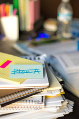 No Plan; Stack of Documents and Laptop at working Desk.