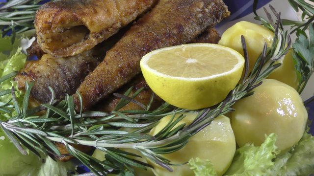 Marine fried fish with fresh herbs on the table
