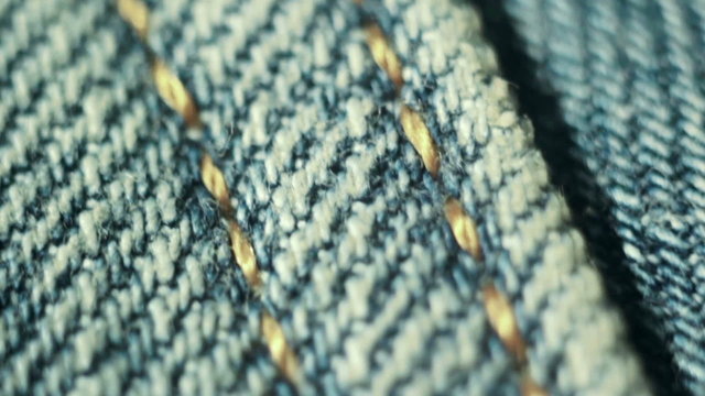 Blue jeans. Stitch. Macro. Slow motion.