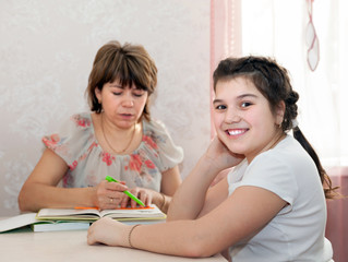 Obraz na płótnie Canvas Mom and daughter doing homework at home.