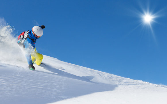 Skier skiing downhill in high mountains