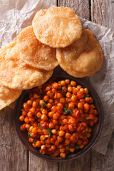 Delicious Indian Chana masala and puri close-up. Vertical top view
