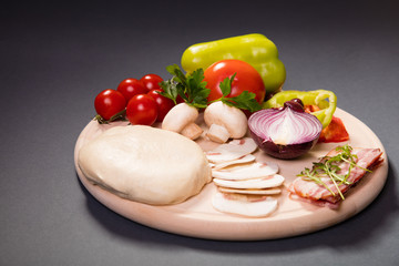 Raw ingredients for pizza on the wooden board