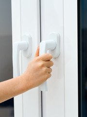 Child tries to open window. Dangerous situation at home.