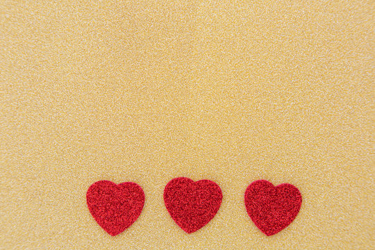 drei Herzen auf goldenem Hintergrund