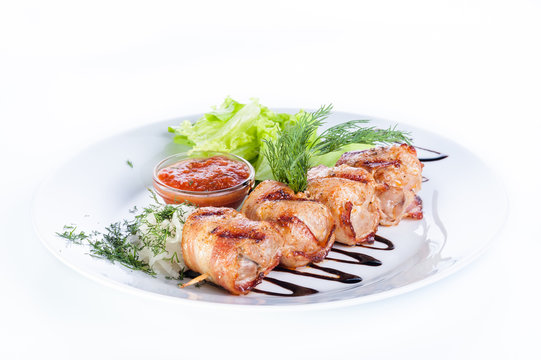 Skewers of beef and pork with parsley, onion and lettuce on a wh