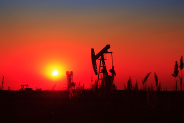 Oil field scene, the evening of beam pumping unit in silhouette