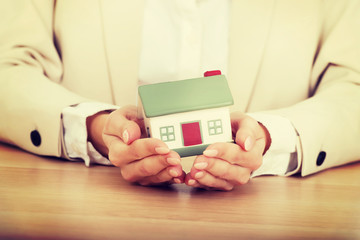 Businesswoman presenting a model house.