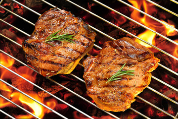 Grilled pork steaks on the flaming grill
