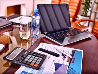 Business still life with calculator and lap top on table in office.