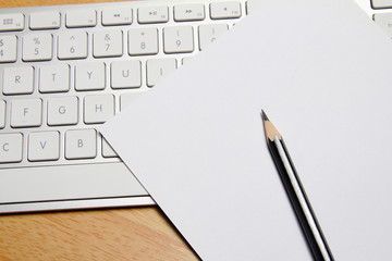 Pencil, keyboard and paper on table