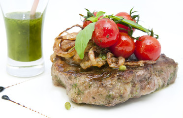 Grilled steak with sauce and greens on white background