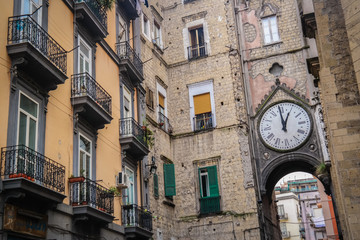 Fototapeta na wymiar Building with clock arch in historic center of Naples