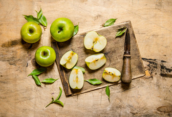 Sliced green apples on a wooden board.