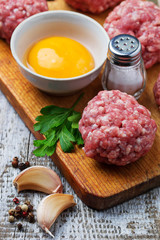 Raw meatballs on a chopping board