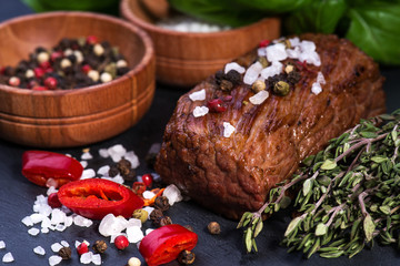  Beef Steak, salt, pepper, garlic, rosemary  on the black board, background.