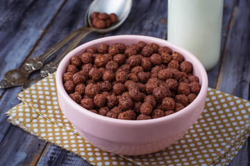 Chocolate cereal balls in bowl and milk