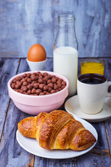 Croissant, cereal flake, coffee, milk, orange juice, boiled egg