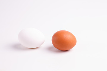 Brown and white chicken eggs lying on a white table.