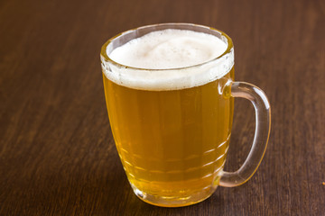 Mug of beer on wooden background