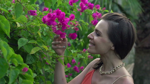 Happy woman smelling flowers in garden, super slow motion 120fps
