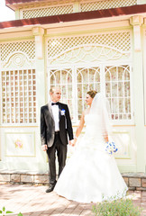 Elegant bride and groom posing together outdoors on a wedding day