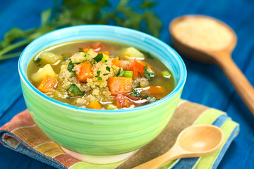 Vegetarian quinoa soup with carrot, potato, leek and tomato, sprinkled with parsley and scallion in...