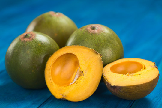 Peruvian fruit called Lucuma (lat. Pouteria lucuma), used to prepare juices, milkshakes, yogurts, ice cream and other desserts (Selective Focus, Focus on the standing lucuma half)