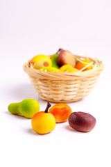 Basket with marzipan sweets in the form of fruit on a white tabl