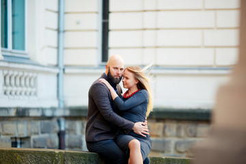 beautiful young couple in love, hugs, near the ancient building. man in jacket