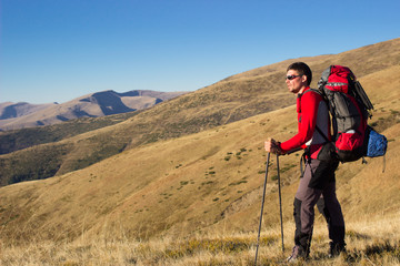 Hiker hiking in the mountains on a sunny day.