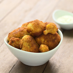 Freshly prepared breaded cauliflower in bowl with mayonnaise to dip in the back (Selective Focus, Focus on the front of the top cauliflower heads)