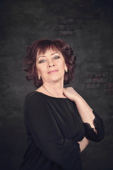 Fototapeta premium Woman in black dress on gray background