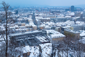 Ljubljana, Slovenia - January 3, 2016. Snowy Ljubljana city twilight view from the hill in the center.
