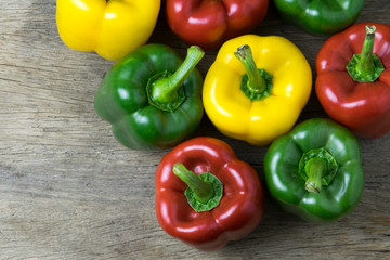 Colored bell peppers on wooden table