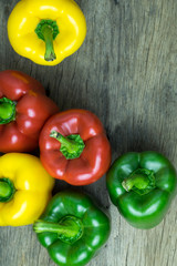 Colored bell peppers on wooden table